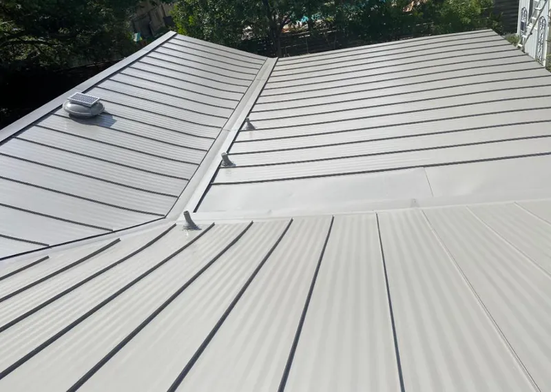 Solar attic fan installed on a metal roof for Roof Ventilation in Fate